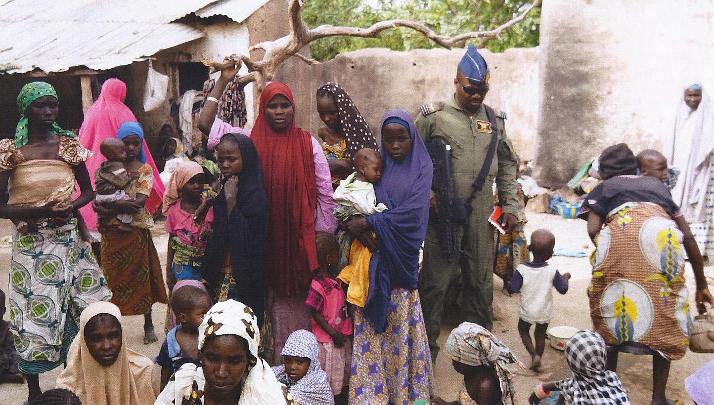 A member of the Nigerian Army standing next to a group of women and children rescued in an operation against the Islamist group Boko Haram in the Sambisa Forest, Borno state, on April 30, 2015. -- PHOTO: AFP