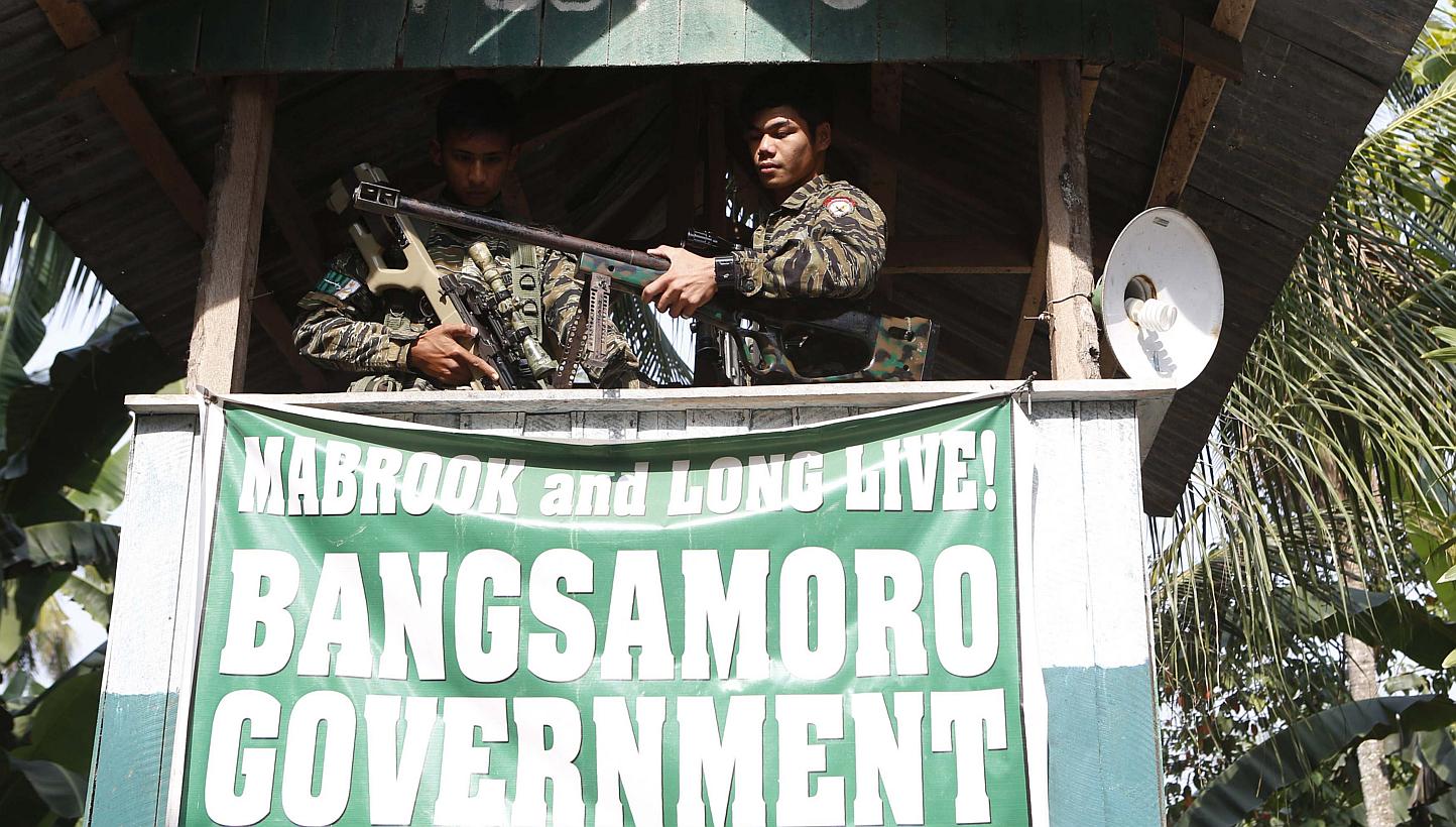 Moro National Liberation Front (MILF) rebels take up position at a guard post at Camp Darapanan rebel base in Maguindanao province, in the southern Philippines, on March 12, 2015. -- PHOTO: REUTERS