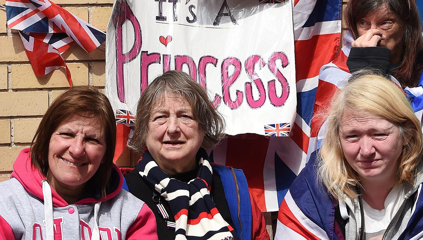 A sign saying 'It's a Princess' hangs above royal well-wishers outside Lindo Wing following the birth of a baby girl at St.Mary's Hospital in Paddington, west London, Britain, on May 2, 2015. Prince William and his wife Kate were to spend their first