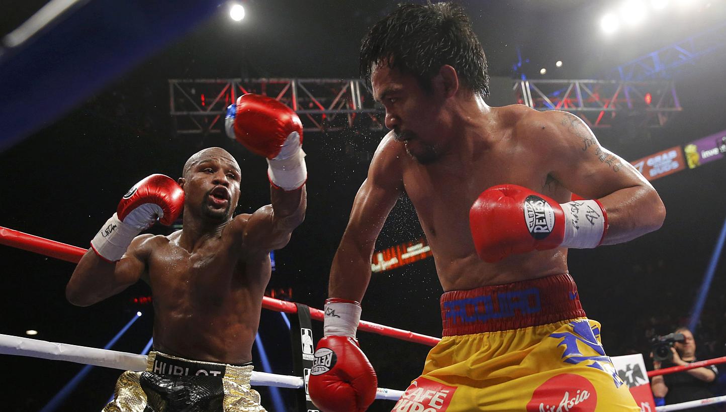 Floyd Mayweather, Jr. of the U.S. (left) and Manny Pacquiao of the Philippines fight in the tenth round during their welterweight WBO, WBC and WBA (Super) title fight in Las Vegas, Nevada, on May 2, 2015. -- PHOTO: REUTERS
