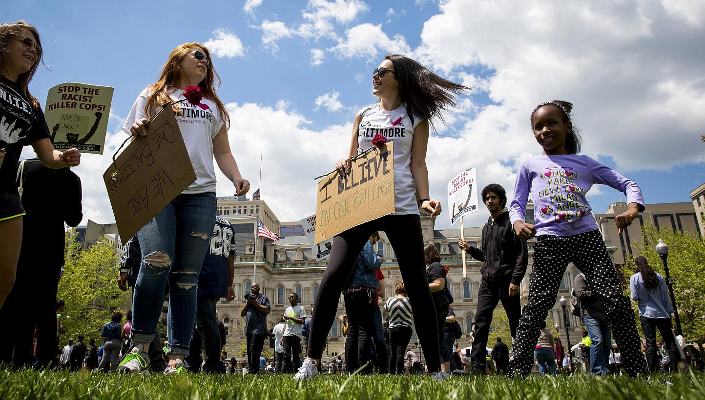 People gather at city hall in Baltimore, Maryland, May 2, 2015. A jubilant Baltimore headed into a weekend of rallies after six police officers were criminally charged over the arrest of 25-year-old black man Freddie Gray whose death led to rioting e