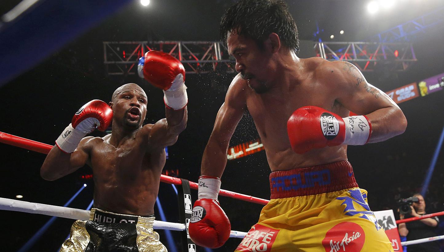Floyd Mayweather of the US (left) and Manny Pacquiao of the Philippines fight in the tenth round during their welterweight WBO, WBC and WBA (Super) title fight in Las Vegas, Nevada, on May 2, 2015. -- PHOTO: REUTERS