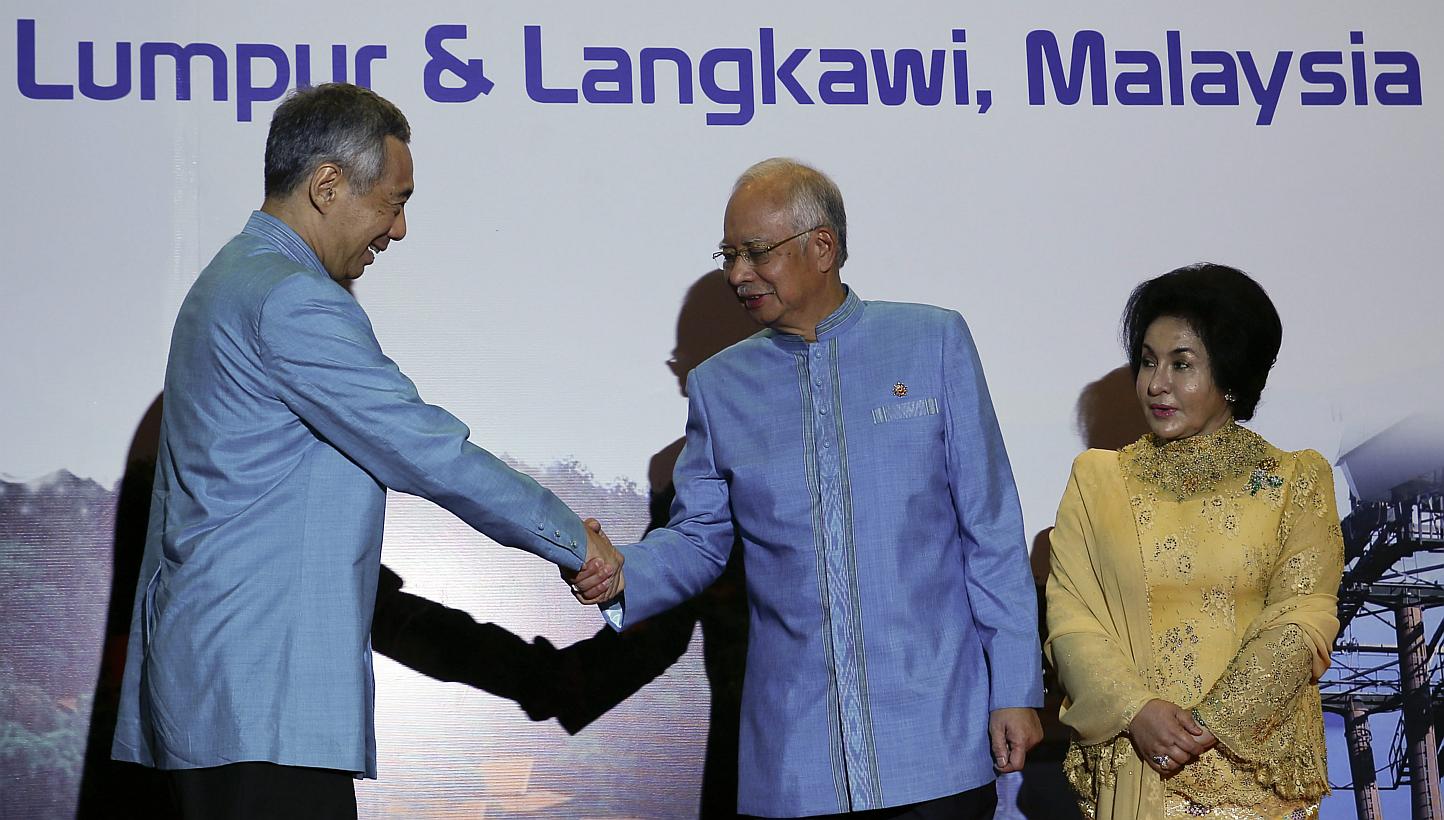 Singapore's Prime Minister Lee Hsien Loong (left) shake hands with Malaysian Prime Minister Najib Razak (centre) during the 26th Asean Summit in Kuala Lumpur on April 26, 2015. -- PHOTO: EPA 