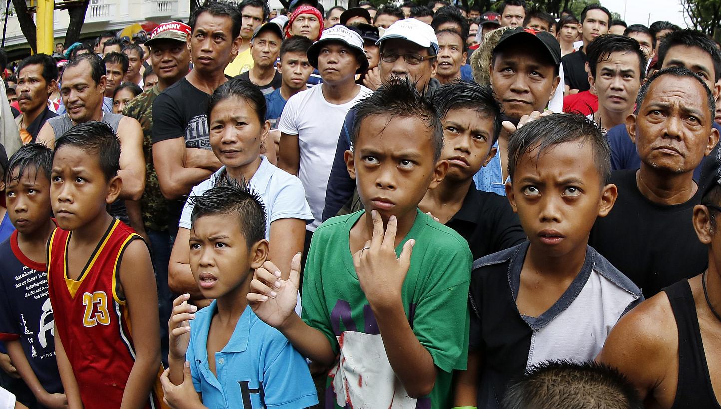 Filipino spectators watch a broadcast from LasVegas, USA of a boxing match between Filipino boxer Manny 'Pacman' Pacquiao and US boxer Floyd Mayweather Junior for the WBC welterweight title bout, at an open plaza in Marikina city, east of Manila, Phi