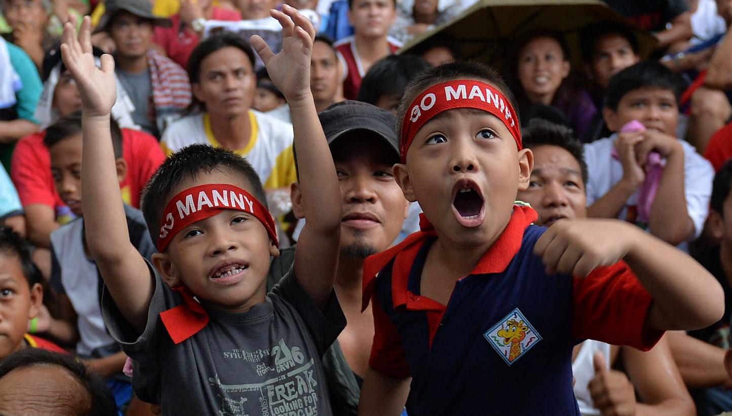 Fans watch a live telecast of the welterweight unification bout between Filipino boxer Manny Pacquiao and US boxer Floyd Mayweather, at a plaza in Marikina City suburban Manila on May 3, 2015. -- PHOTO: AFP