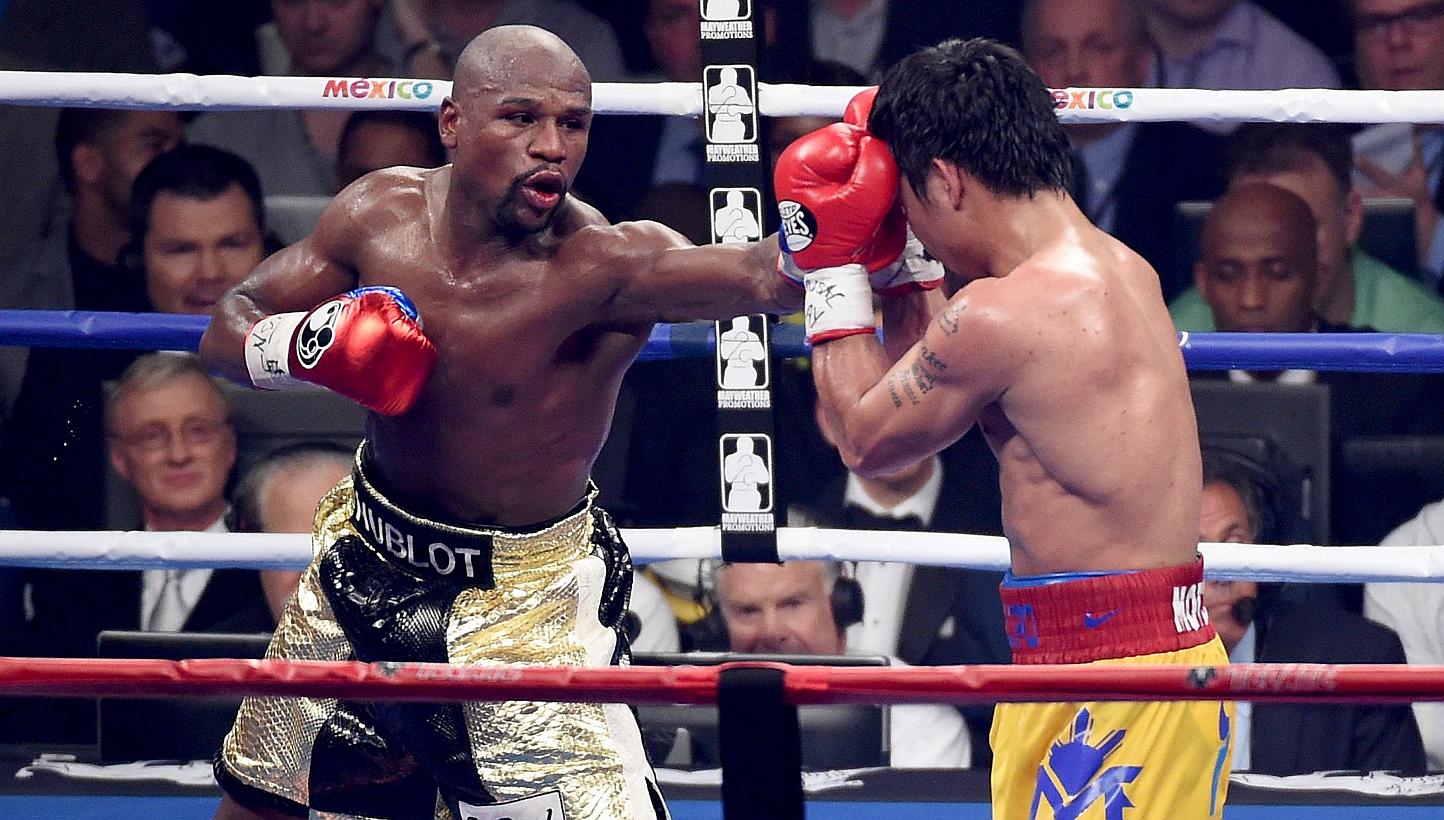 Floyd Mayweather Jr. throws a left at Manny Pacquiao during their welterweight unification championship bout on May 2, 2015 at MGM Grand Garden Arena in Las Vegas, Nevada. -- PHOTO: AFP