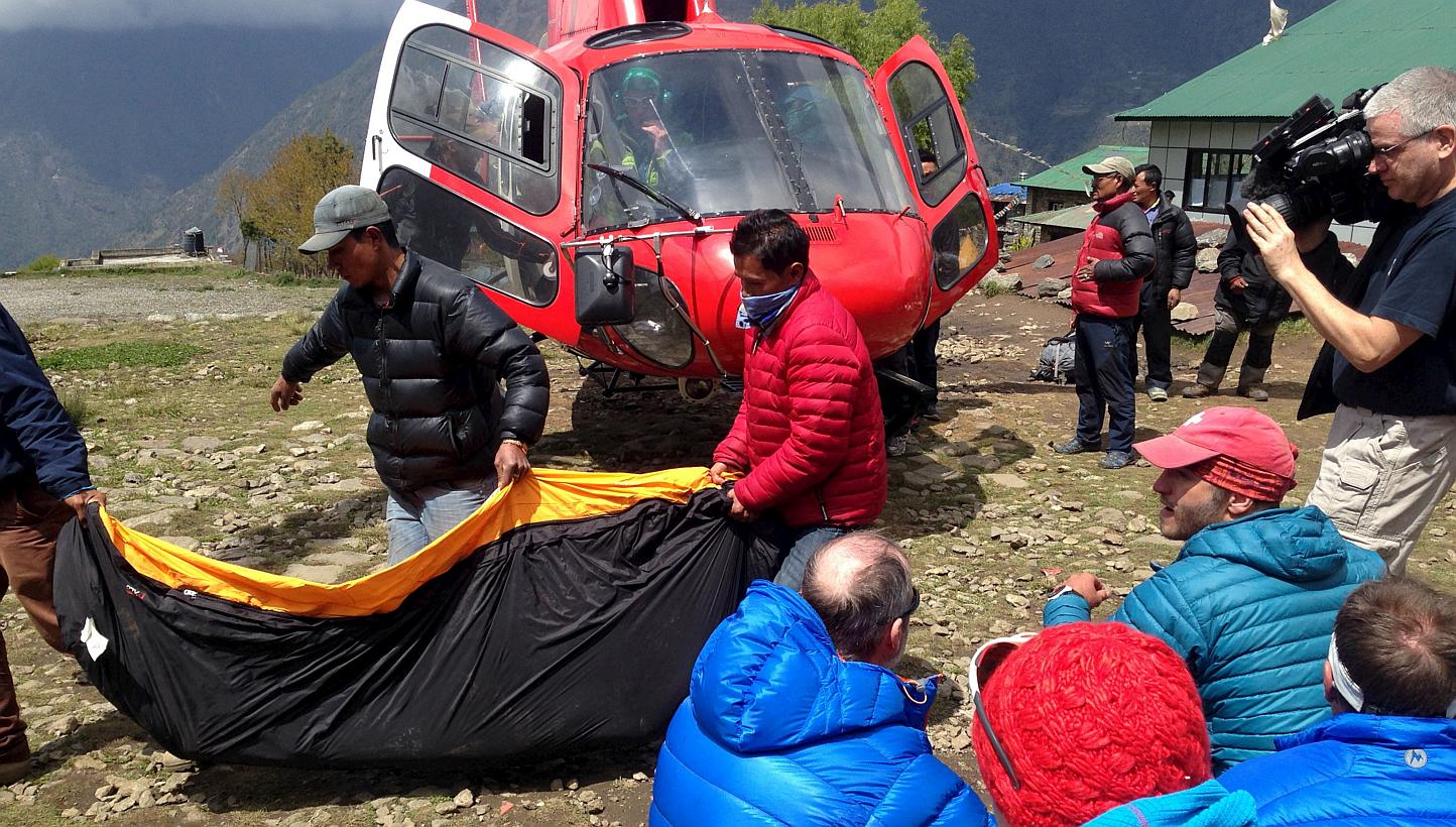 A body bag containing the body of a climber is carried from a helicopter in the Himalayan tourist town of Lukla April 29, 2015.&nbsp;Police have found more than 50 bodies, including those of six foreigners, in Nepal's popular Langtang trekking region