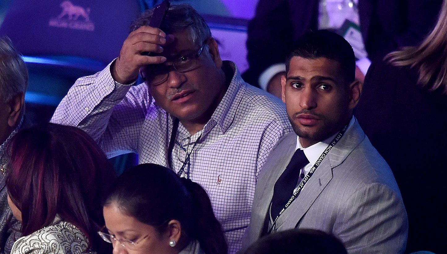Boxer Amir Khan (right) watches the Leo Santa Cruz against Jose Cayetano featherweight bout on May 2, 2015 at MGM Grand Garden Arena in Las Vegas, Nevada on May 2, 2015. -- PHOTO: AFP