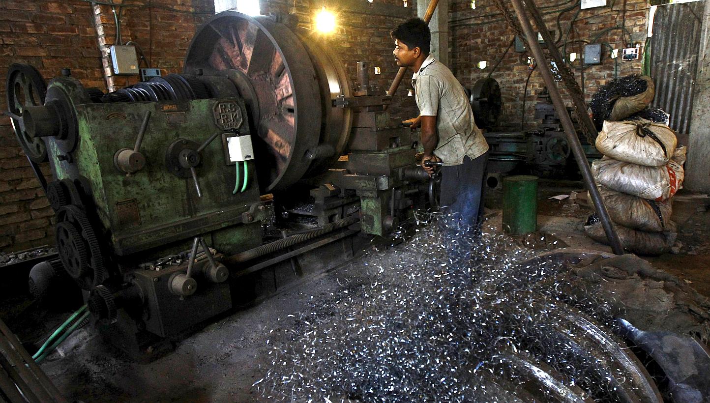 A worker makes gear parts for cranes inside a workshop on the outskirts of Kolkata on April 2, 2015. Indian manufacturing growth eased in April as domestic demand softened, despite factories cutting prices for the first time in nearly two years, a bu