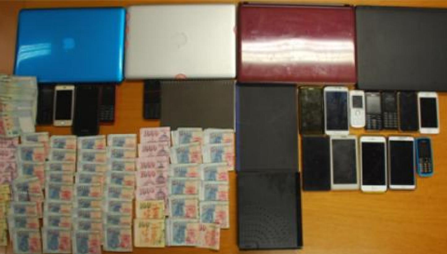 Police arrested nine men and two women suspected of being involved in a remote gambling operation, and seized cash amounting to about $215,000, computers, mobile phones, betting records and bank transaction record booklets. -- PHOTO: SINGAPORE POLICE