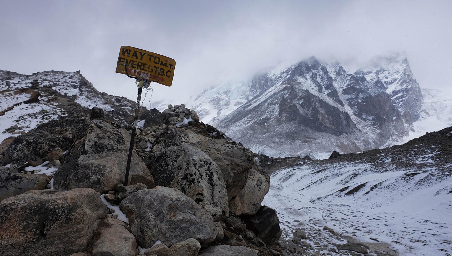 A sign showing the way to Everest Base Camp high in the Khumb Glacier stands among rocks on April 26, 2015, one day after an earthquake triggered avalanche swept through parts of the base camp killing scores of people. -- PHOTO: AFP