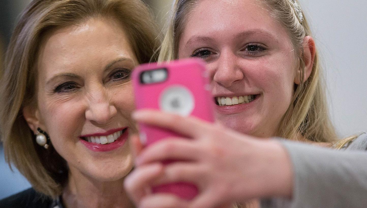 Mrs Carly Fiorina (left) posing for a selfie with a supporter at a Republican event at a high school in Iowa last month. Her mixed record at HP is under scrutiny ahead of her expected presidential bid today.