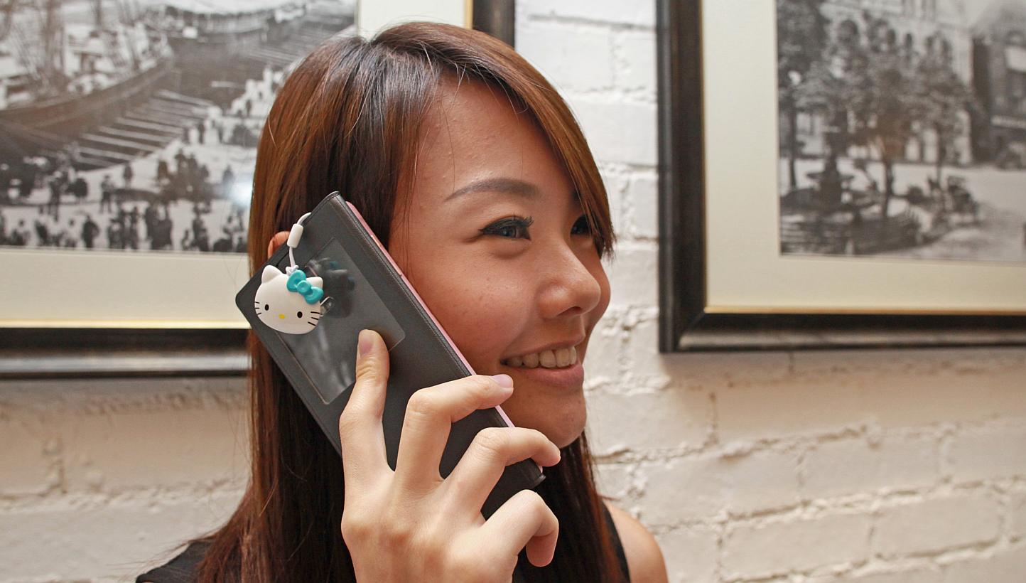 Ms Claire Ang of EZ-Link poses with the limited edition blue Hello Kitty Charm. This new trinket or charm can be used in place of ez-link card. -- ST PHOTO: MIKE LEE