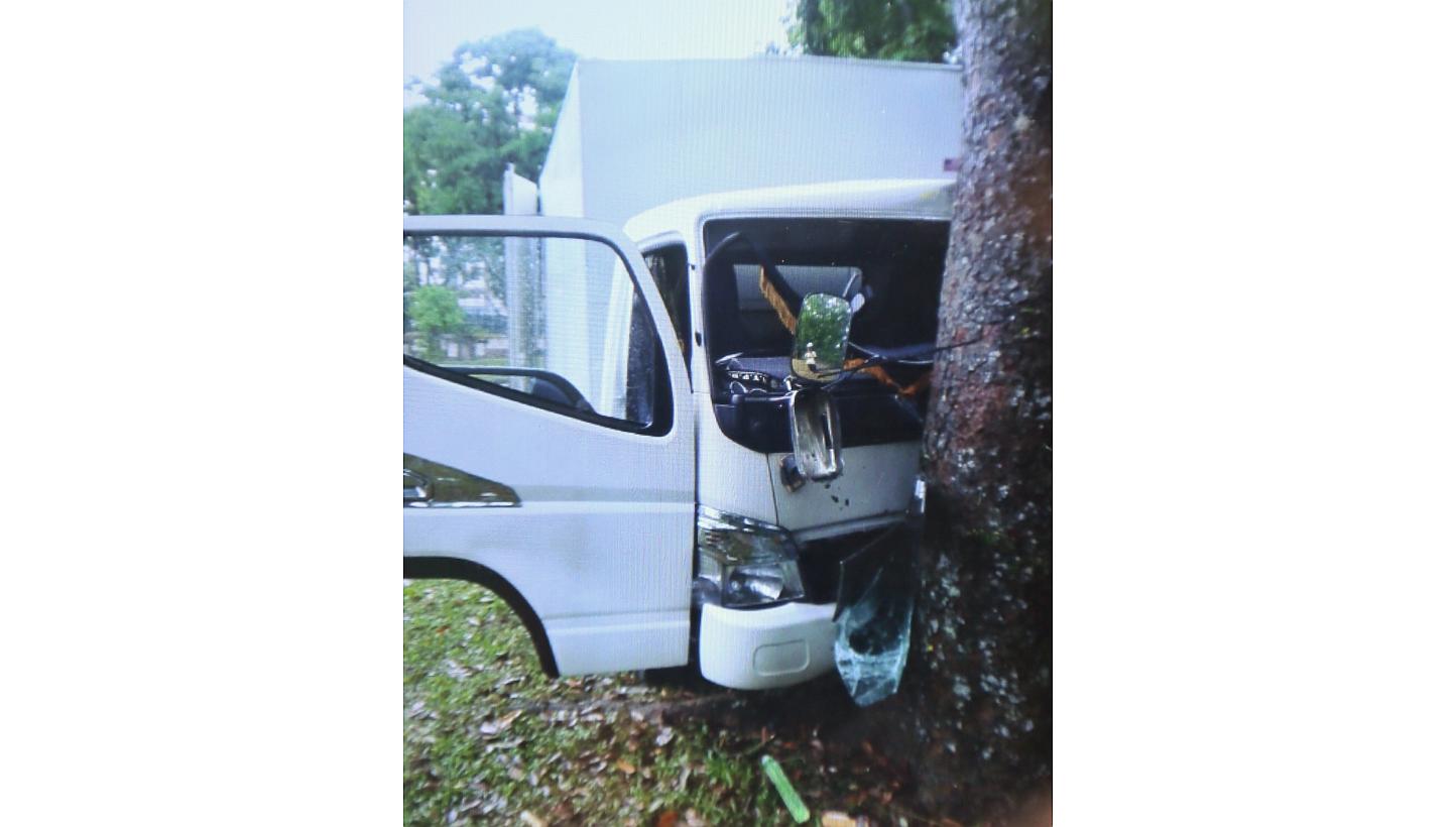 At least one man has died in an accident after a lorry slid during wet weather and hit a tree at Yishun Avenue 1 on Sunday morning. -- PHOTO: SHIN MIN