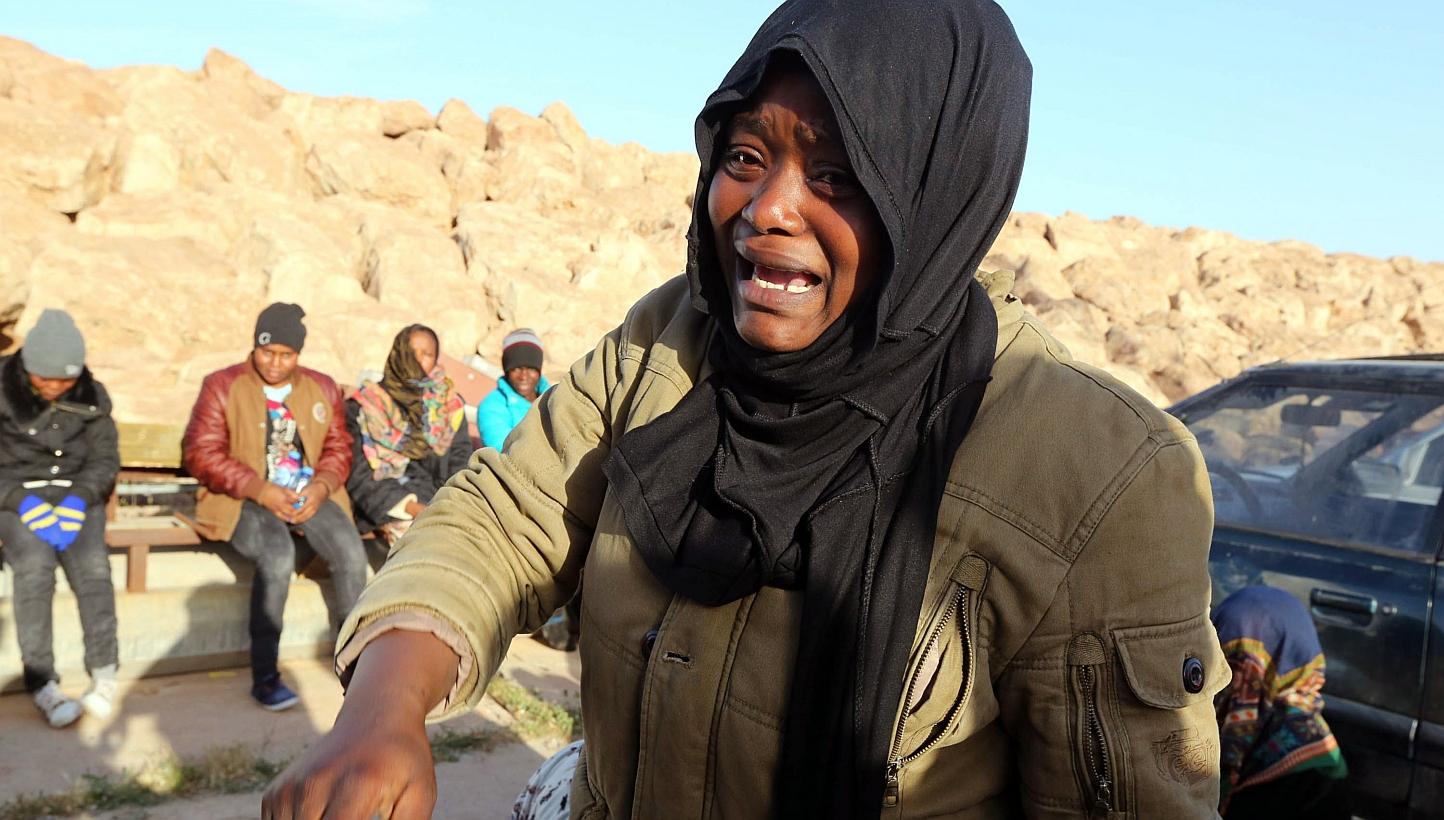 A migrant woman cries after disembarking from a boat following the interception by the Libyan coastguard of five boats carrying around 500 mostly African migrants trying to reach Europe, on Sunday, in the city of Misrata, east of the capital Tripoli.