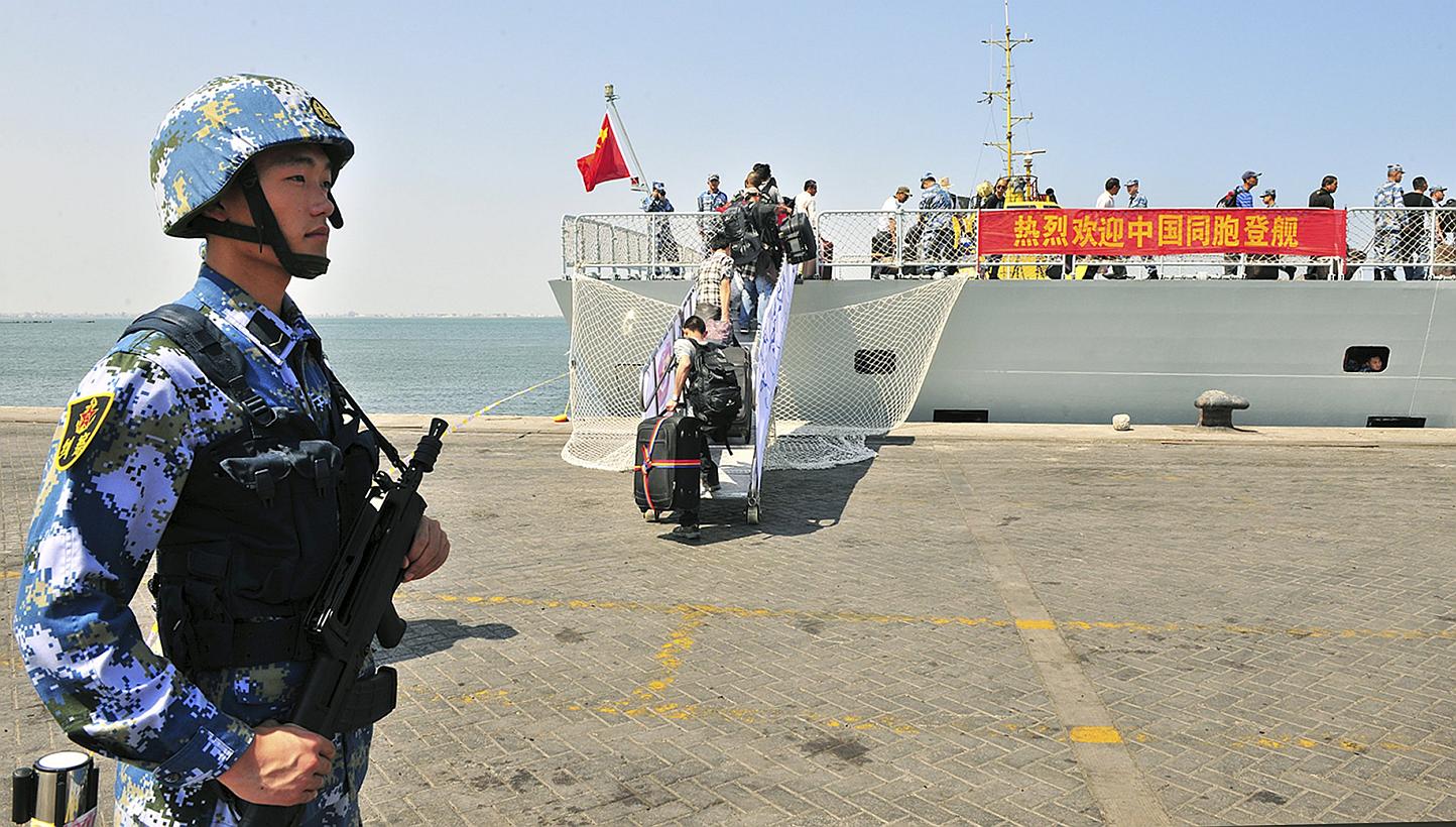 A navy soldier (left) of People's Liberation Army (PLA) stands guard as Chinese citizens board the naval ship "Linyi" at a port in Aden, on March 29, 2015. -- PHOTO: REUTERS
