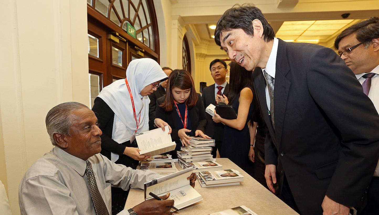 Professor Jayakumar autographing a copy of his book for Mr Haruhisa Takeuchi, Japan Ambassador to Singapore. -- ST PHOTO: SEAH KWANG PENG