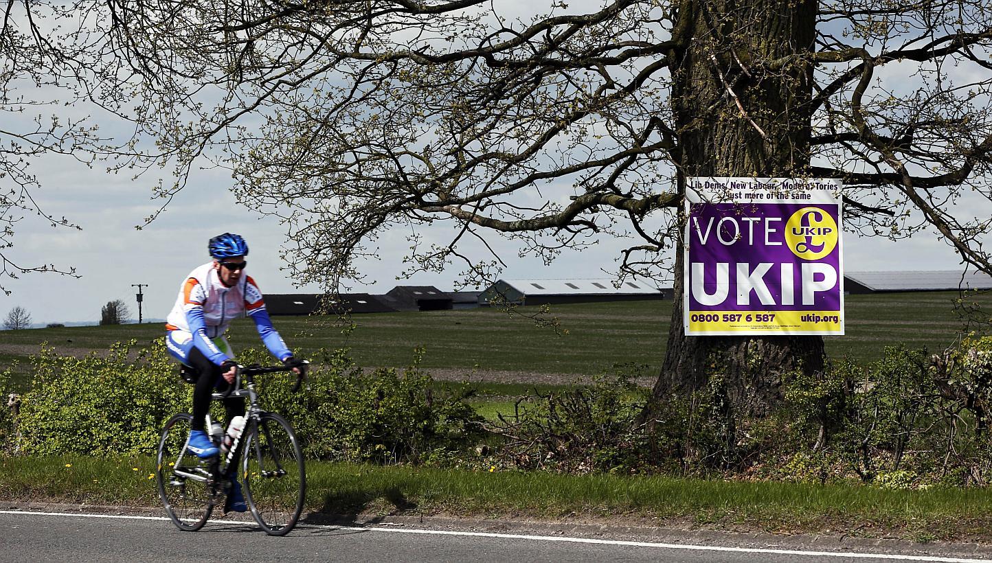 A cyclist riding past a UK Independence Party (UKIP) election campaign poster on the outskirts of Aylesbury, north-west of London, on April 30, 2015. UKIP candidate Robert Blay has been suspended after a video of him insulting Conservative rival Rani