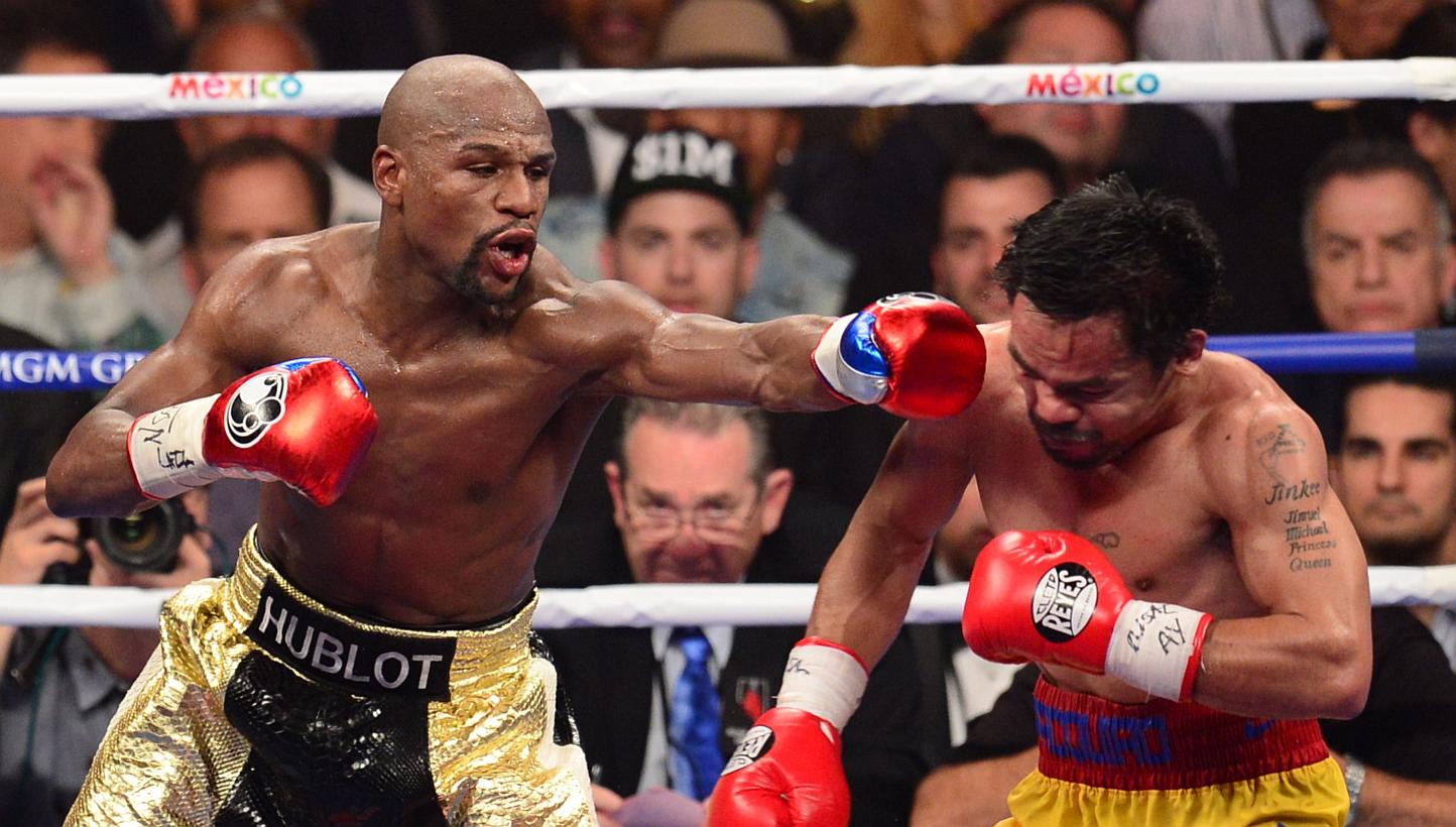Floyd Mayweather (left) connecting against Manny Pacquiao during their bout on May 2, 2015, at the MGM Grand Garden Arena in Las Vegas, Nevada. -- PHOTO: AFP 