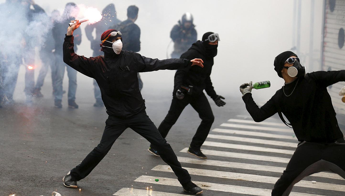 Protesters throwing bottles and flares during a rally against Expo 2015 in Milan, Italy, on May 1, 2015. Swiss watchmaker Rolex demanded an apology from the Italian government saying that the latter had damaged the former's reputation by portraying t