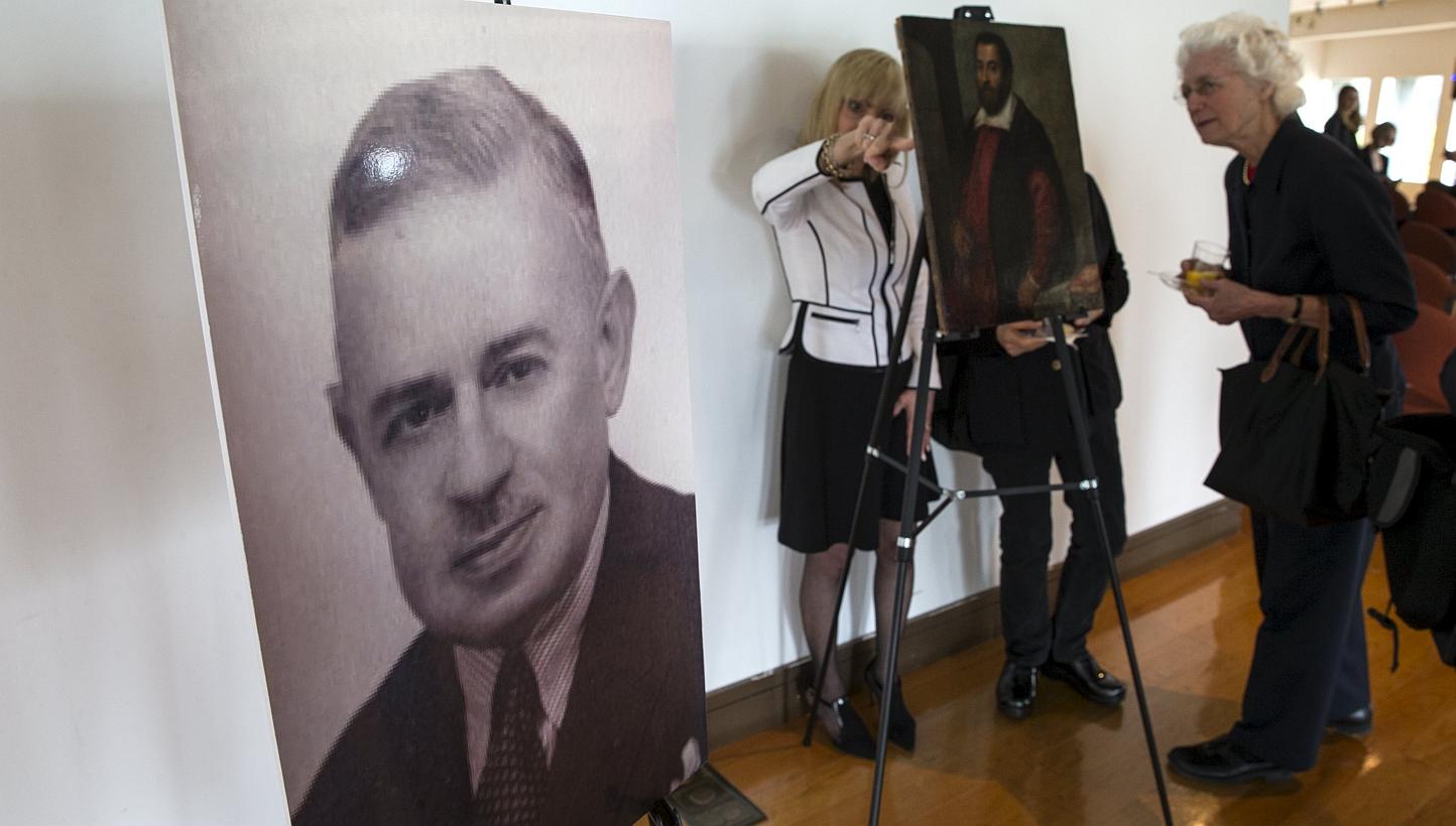 A photograph of German Holocaust victim Dr. August Liebmann Mayer, stands next to the 17th century painting Portrait of a Man which belonged to Dr Mayer at a ceremony at the Jewish Heritage Museum in New York officially returning the painting to Maye