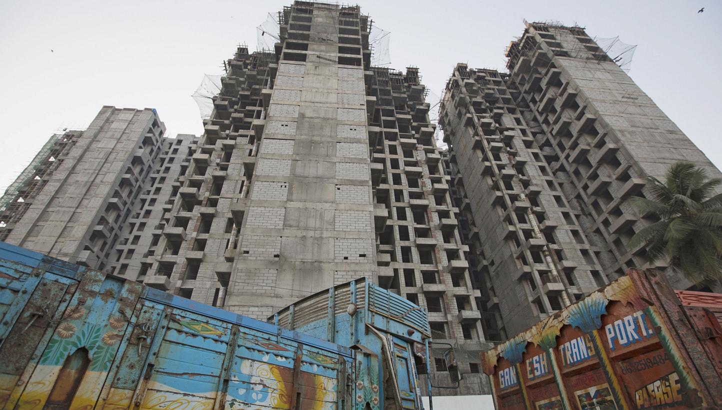 Trucks are parked at the site of an under-construction residential building project in Mumbai on March 19, 2015. India's federal cabinet on Wednesday relaxed rules to allow foreign funds to invest in real estate investment trusts (Reits), a move desi