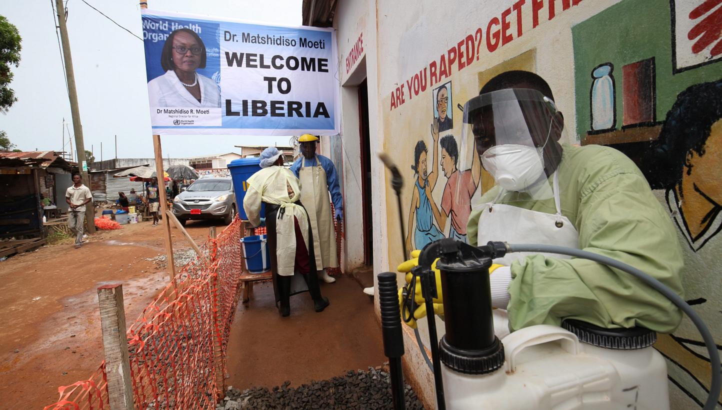 Health workers at the entrance of the Redemption Hospital in Newkru town in a surburb of Monrovia, Liberia, on April 22, 2015. -- PHOTO: EPA