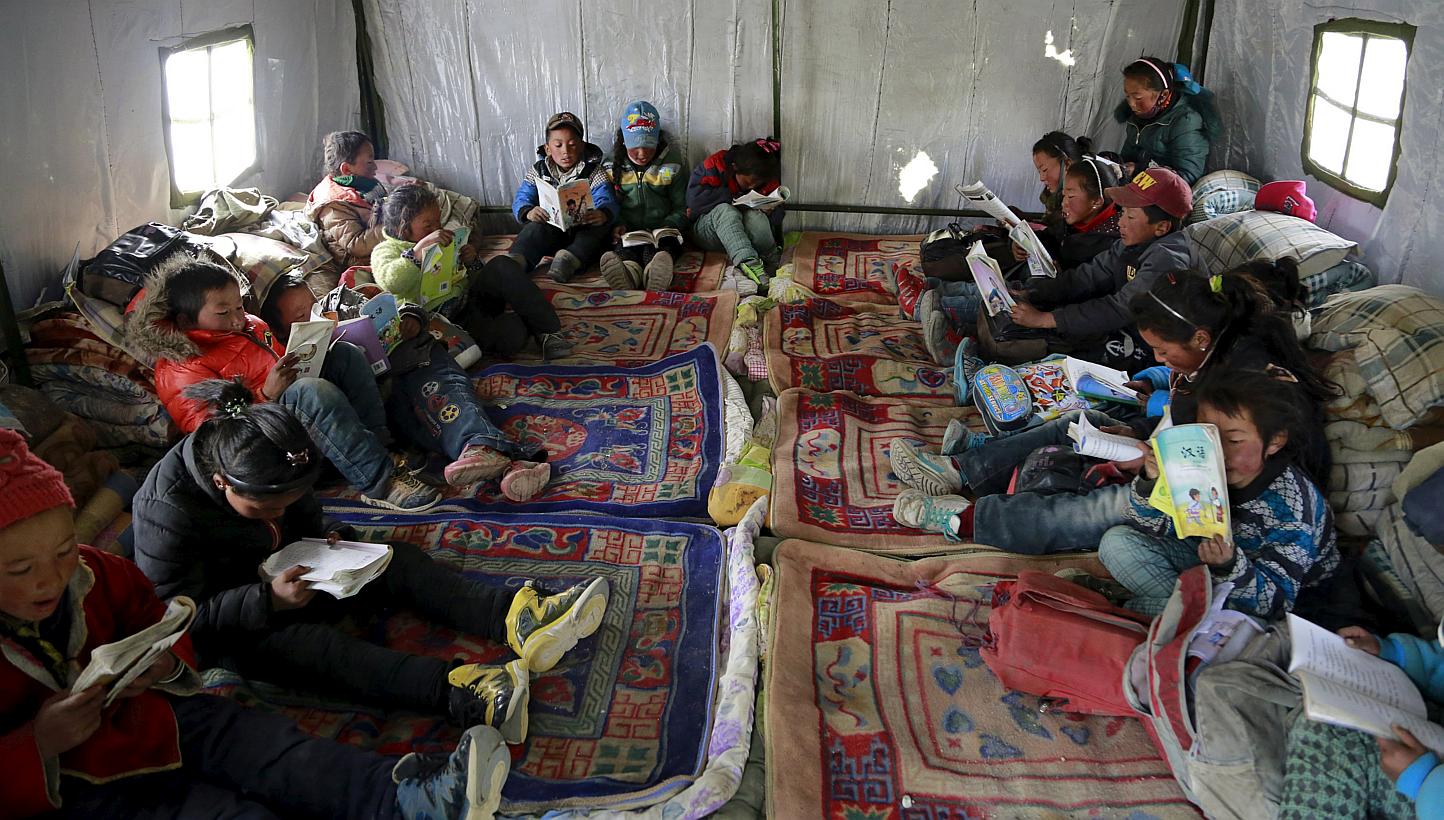 Third-grade students read in a class at a relief tent after the 7.9-magnitude earthquake hit Nepal. The earthquake has left almost a million children without classrooms, the UN children's agency says, calling for urgent action to repair damaged schoo