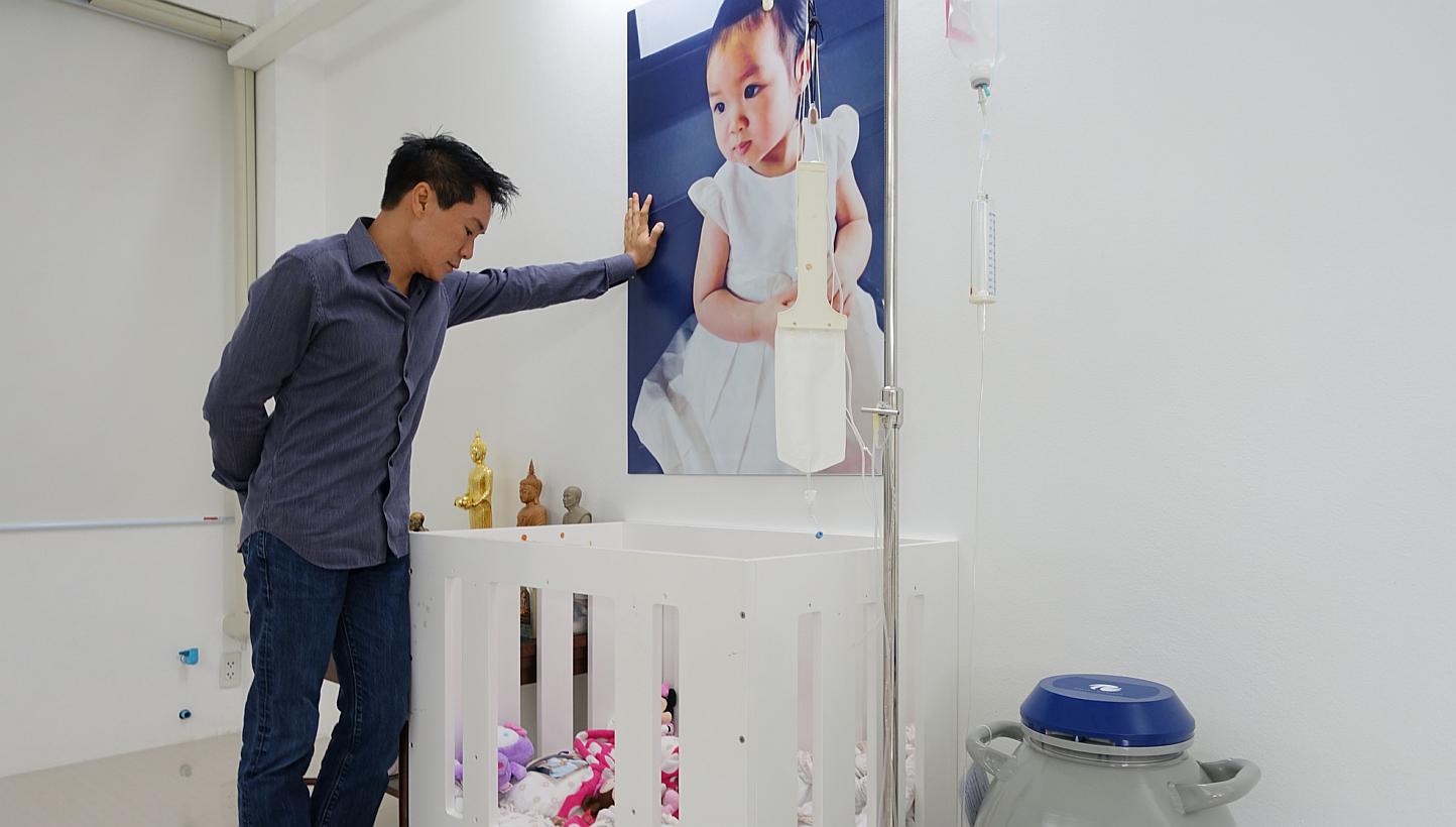 Dr Sahatorn Naovaratpong, a businessman, at the cot where his daughter, Matheryn, used to sleep when she was battling brain cancer, until her death in January 2015. -- ST PHOTO: TAN HUI YEE