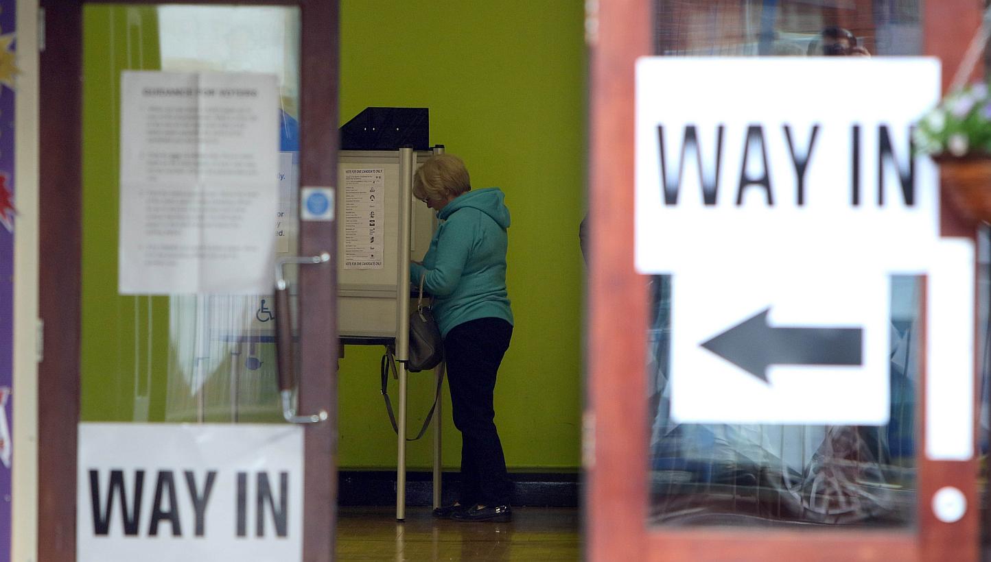 A voter prepares to cast her vote in Belfast on May 7, 2015. -- PHOTO: AFP&nbsp;