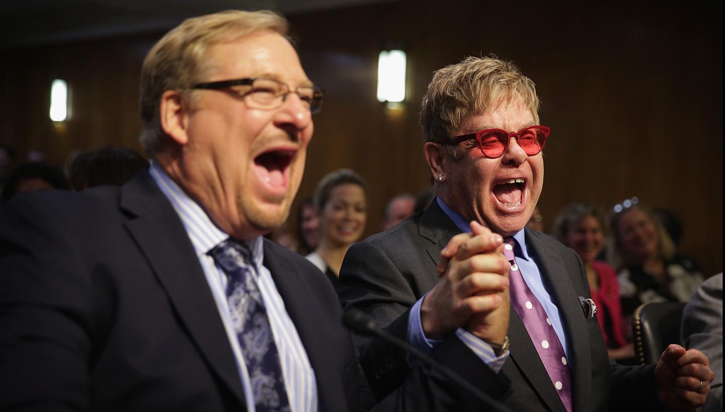 Singer/songwriter Elton John (right) and pastor of the Saddleback Church Rick Warren (left) shake hands prior to a hearing before the State, Foreign Operations and Related Programs Subcommittee of the Senate Appropriations Committee on Tuesday on Cap