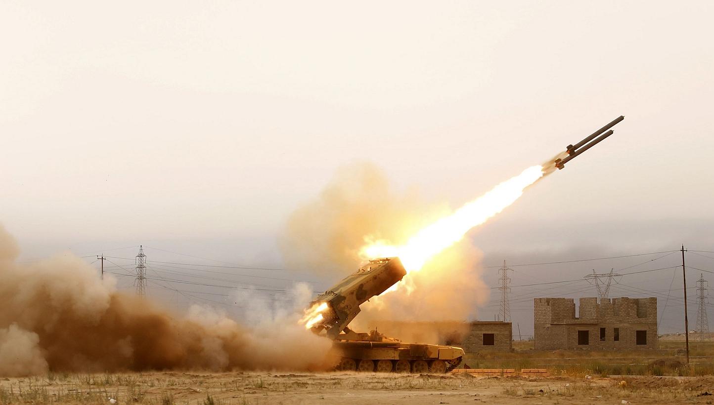 Iraqi pro-government forces, including fighters from the Shiite Muslim Al-Abbas popular mobilisation unit, fire a rocket during an operation to retake the Baiji oil refinery from ISIS on April 16. -- PHOTO: AFP
