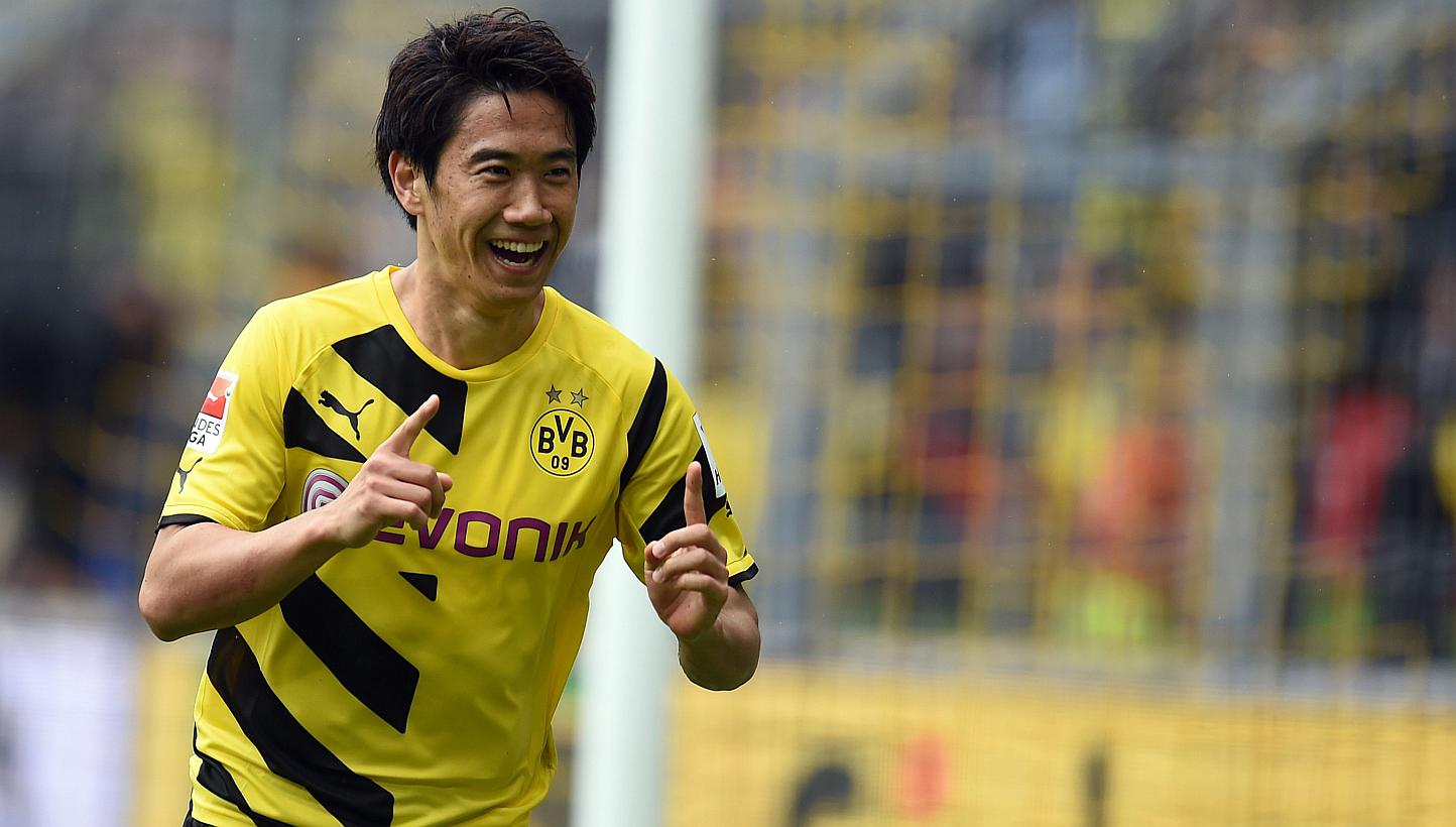 Shinji Kagawa (above), Marco Reus and the rest of Borussia Dortmund's star-studded squad will be showcasing their football skills in Asia this July - including a stopover in Singapore. -- PHOTO: AFP