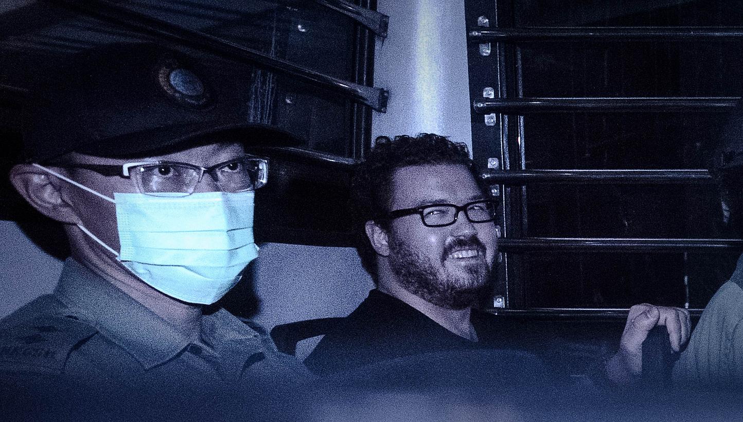 British banker Rurik Jutting (right), charged with the grisly murders of two women, smiles as he sits in a prison van leaving the eastern court in Hong Kong on Nov 10, 2014. -- PHOTO: AFP