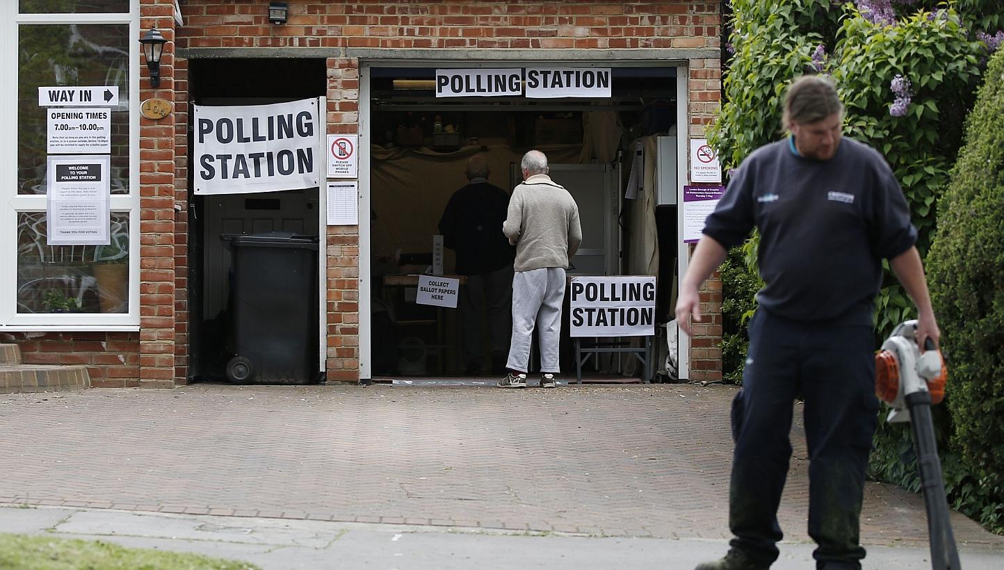 A man arrives to vote at a polling station set up in the garage of a house in Croydon on Tuesday, as Britain holds a general election. -- PHOTO: AFP