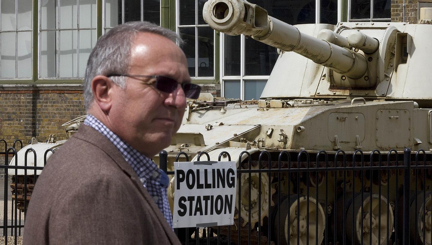 A man passes a 2S3 M-1973 Akatsiya 152-mm self-propelled gun howitzer tank outside the Greenwich Heritage Centre, set up as a polling station in London on Thursday, as Britain holds a general election. -- PHOTO: &nbsp;AFP