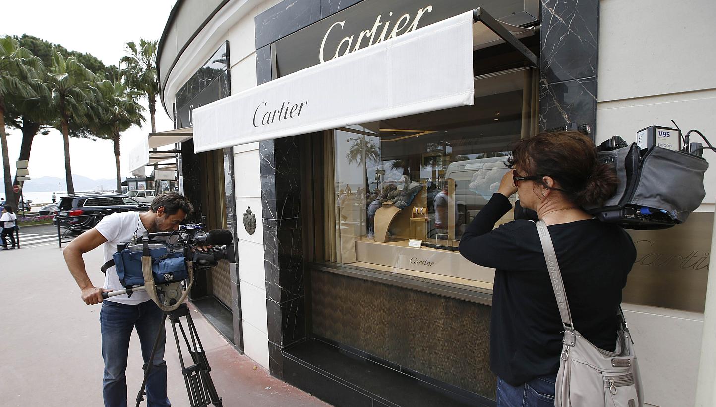 Journalists work in front of the Cartier jewellery shop on the Croisette in Cannes, French Riviera, on May 5, 2015, after the hold up by four armed men who fled with a large amount of jewellery.With France still on high alert after January's attacks