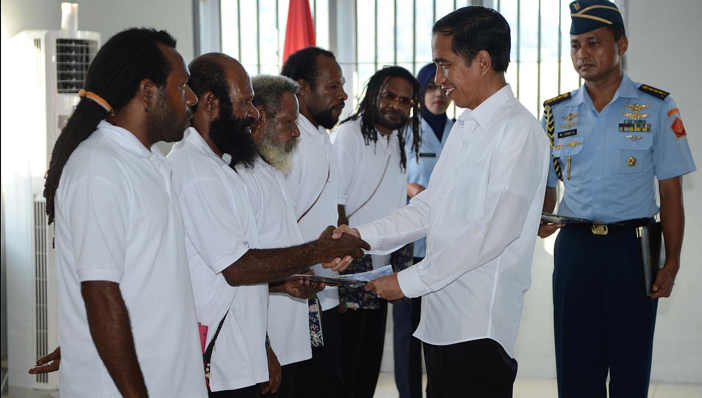 Indonesia's President Joko Widodo (2nd R) shakes hands with freed Papuan political prisoner Kimanus Wenda (2nd L) while four others Jefrai Murib (L) Apotnalogolik Lokobal (3rd L) Numbungga Telenggen (4th L) and Linus Hiluka (3rd R) looks on during a 
