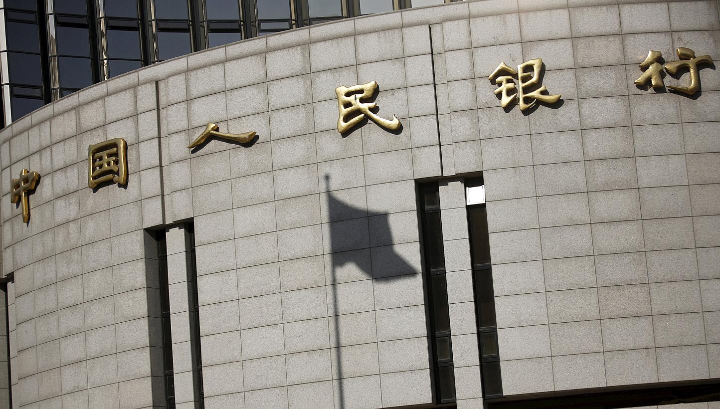 A fluttering Chinese national flag casts its shadow on the headquarters of the People's Bank of China, China's central bank, in central Beijing in this Nov 24, 2014 file photograph. China's central bank cut its benchmark interest rate on May 10, 2015