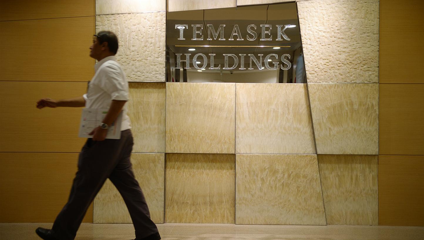 A man walks pass the Temasek Holdings office on Feb 16, 2015. A constitutional change was sought on Monday to make Temasek Holdings a bigger contributor to the Government's coffers, as Singapore prepares for more social and infrastructure spendi