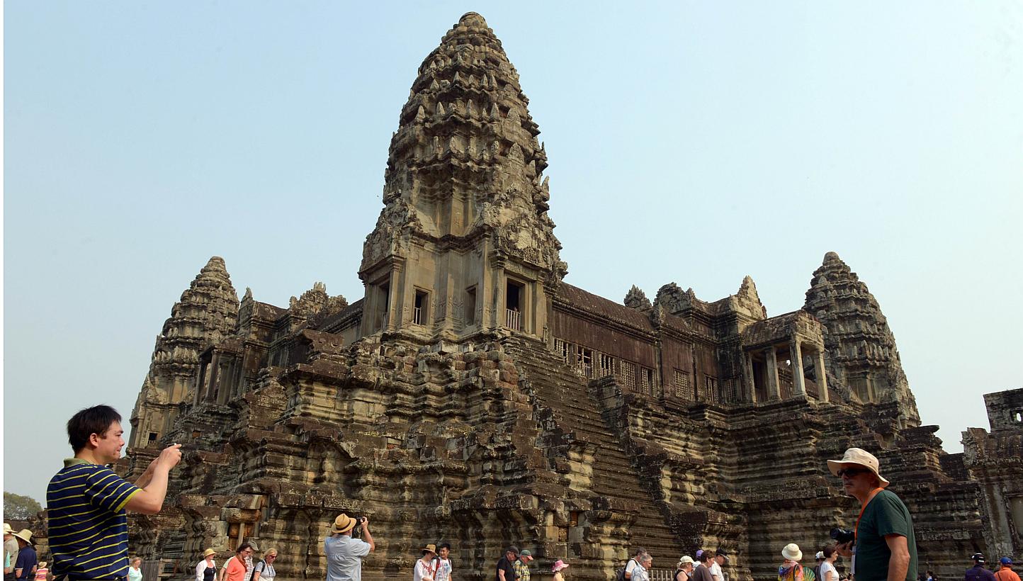 Tourists at the Angkor Wat temple in Siem Reap, Cambodia on March 20, 2015. Three tourists appeared in a Cambodian court on Monday accused of taking photographs of their bare bottoms inside the country's famed temple complex. -- PHOTO: AFP
