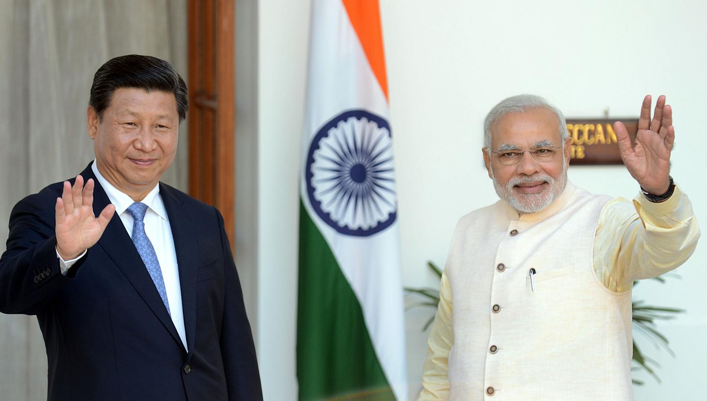 Chinese President Xi Jinping (left) and Indian Prime Minister Narendra Modi waving before delegation talks in New Delhi, in this Sept 18, 2014 photo. Mr Modi will take his global investment push to China this week, as Asia's rival superpowers look to