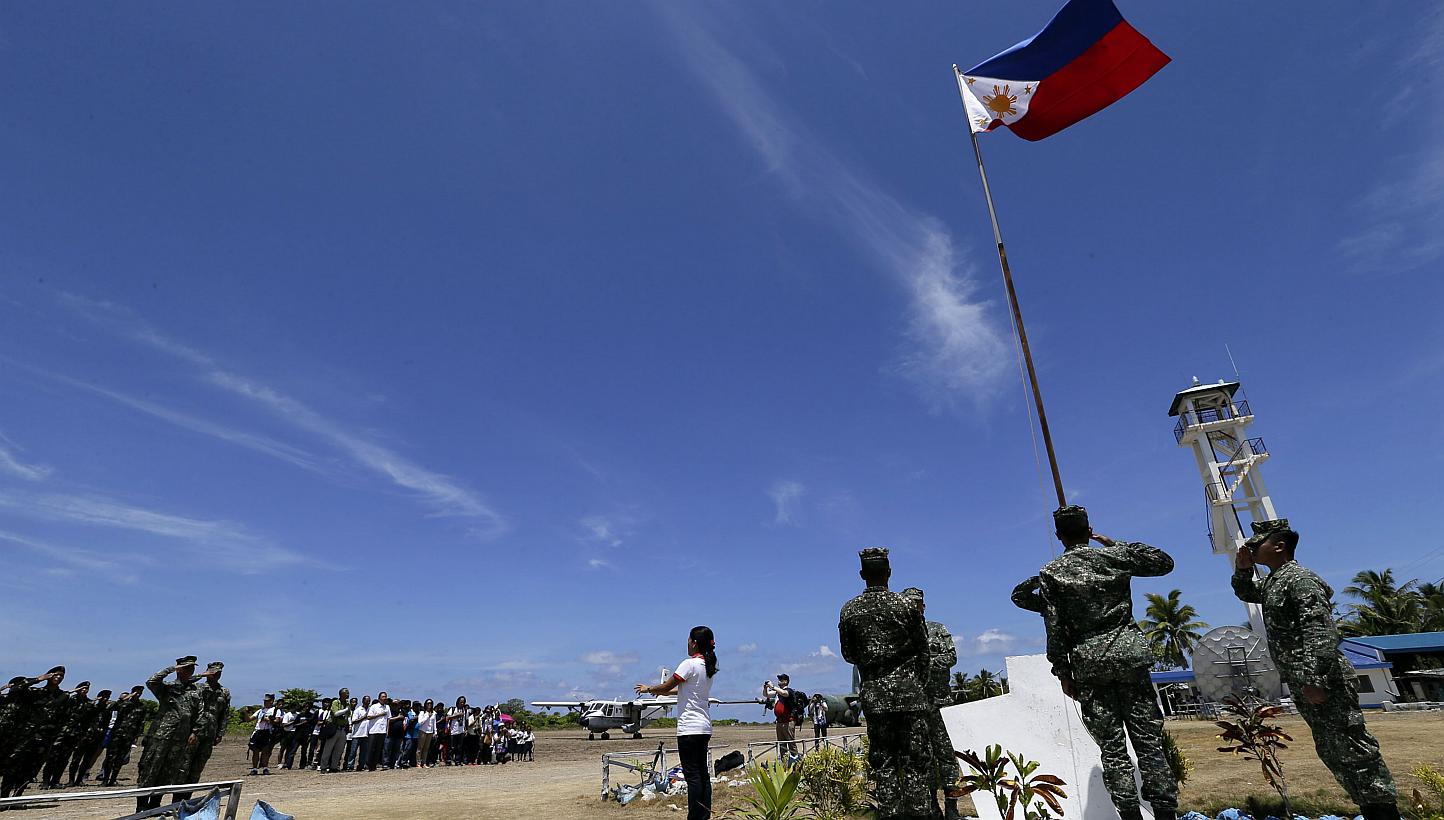 Filipino residents and soldiers conduct a flag raising ceremony during the visit of Philippines military chief General Gregorio Catapang Junior in Pagasa Island (Thitu Island) at the Spratly group of islands in the South China Sea, west of Palawan, o