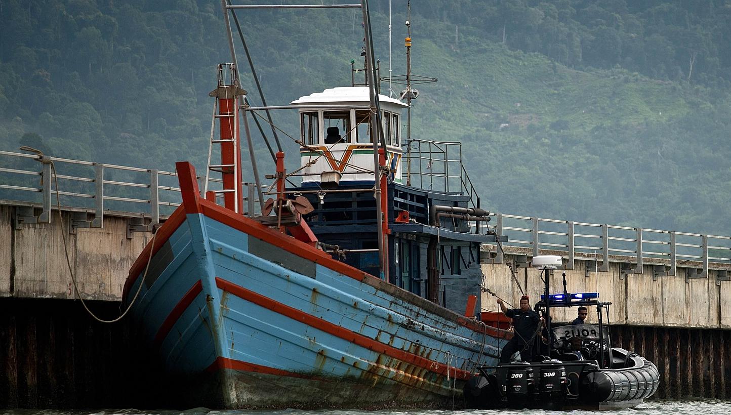 Malaysian Maritime police inspect one of the boats which carried illegal migrants in Langkawi on May 12, 2015. -- PHOTO: AFP