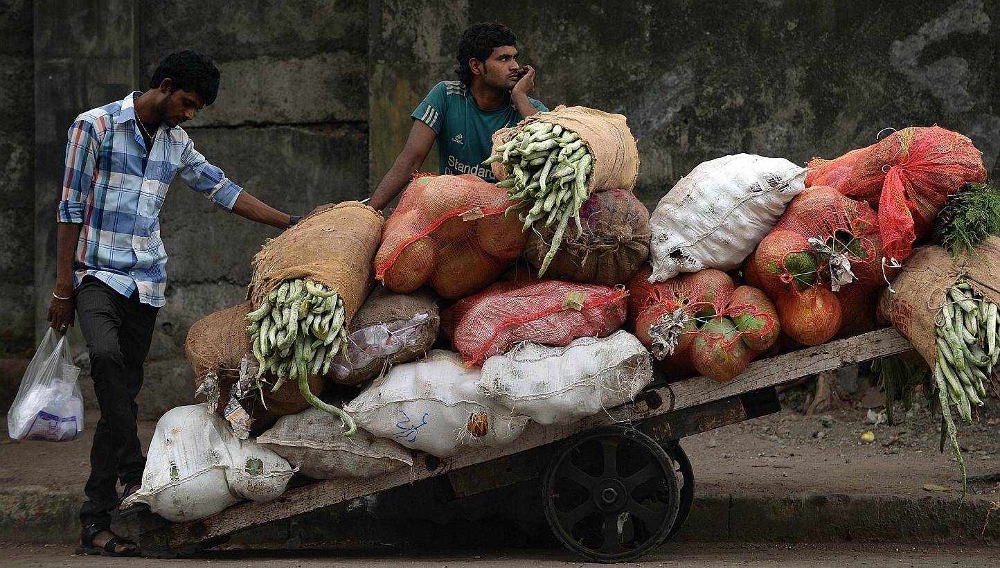 An Indian vendor waits alonside his cart filled with vegetables at the wholesale market in Mumbai on Feb 28, 2015.&nbsp;&nbsp;India's inflation rate fell to its lowest level in four months and growth in industrial output slowed, official data showed 