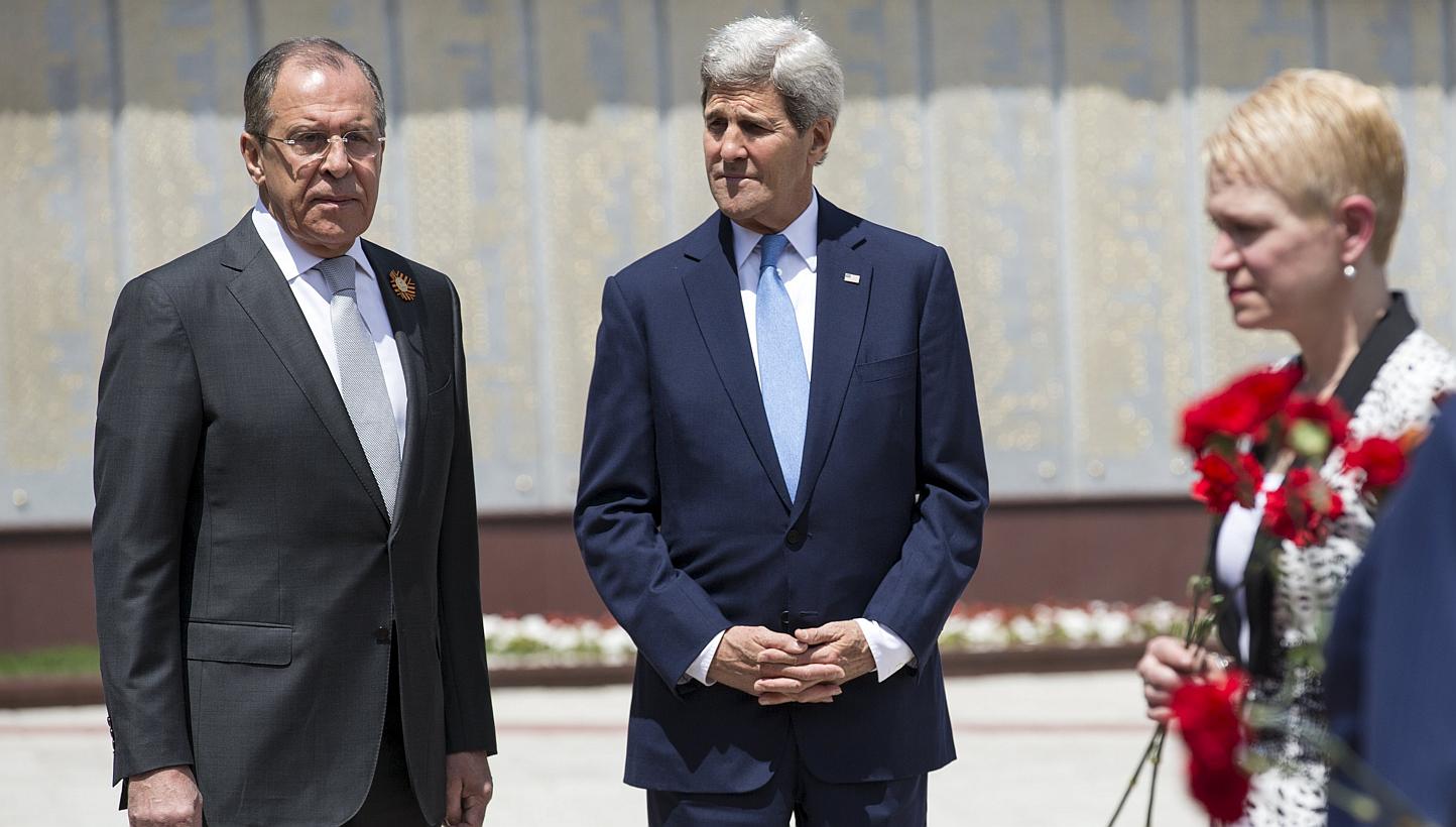 U.S. Secretary of State John Kerry (centre) and Russian Foreign Minister Sergey Lavrov watch as members of the United States and Russian delegations place red flowers at the Zakovkzalny War Memorial in Sochi, Russia May 12, 2015. -- PHOTO: REUTERS&nb