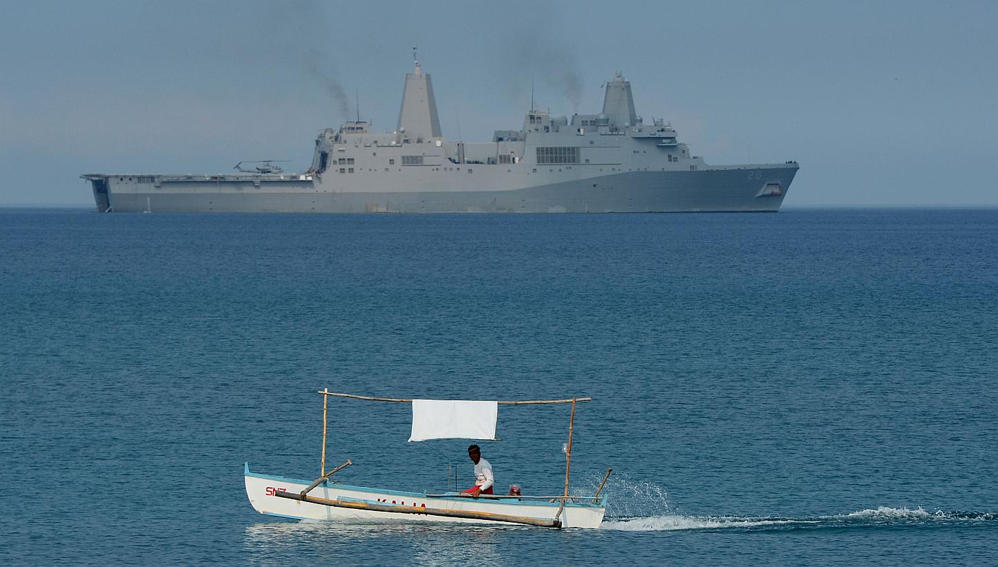 A Filipino fisherman sails past the US Navy amphibious transport dock ship USS Green Bay (LPD-20) during an amphibious landing exercise on a beach at San Antonio in Zambales province on April 21, 2015. China on Wednesday, May 13, said it was "extreme