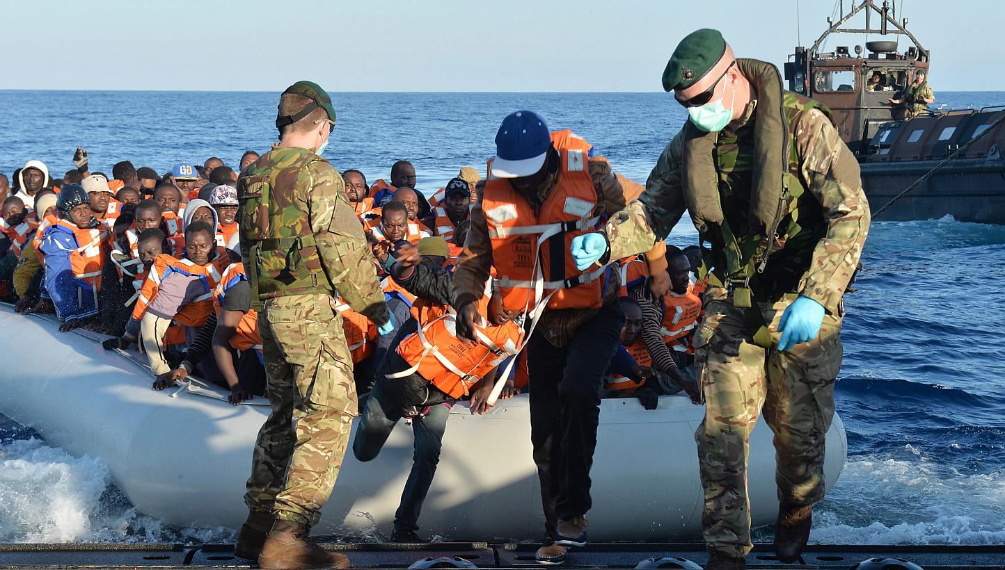 A handout image made available by the British Ministry of Defence (MOD) of Royal Marines leading migrants to safety on a Landing Craft of HMS Bulwark from an inflatable boat on the Mediterraean on May 13, 2015. The EU rejected on Wedne
