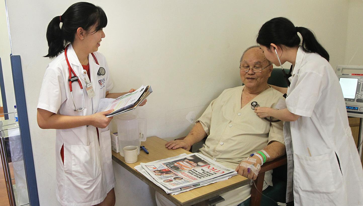 NUS Medicine students Germaine Loo (left) and Alvona Loh with Mr Wee Dick Hoon, 78, a patient at National University Hospital. Eight weeks of their five-year course are devoted to geriatrics.