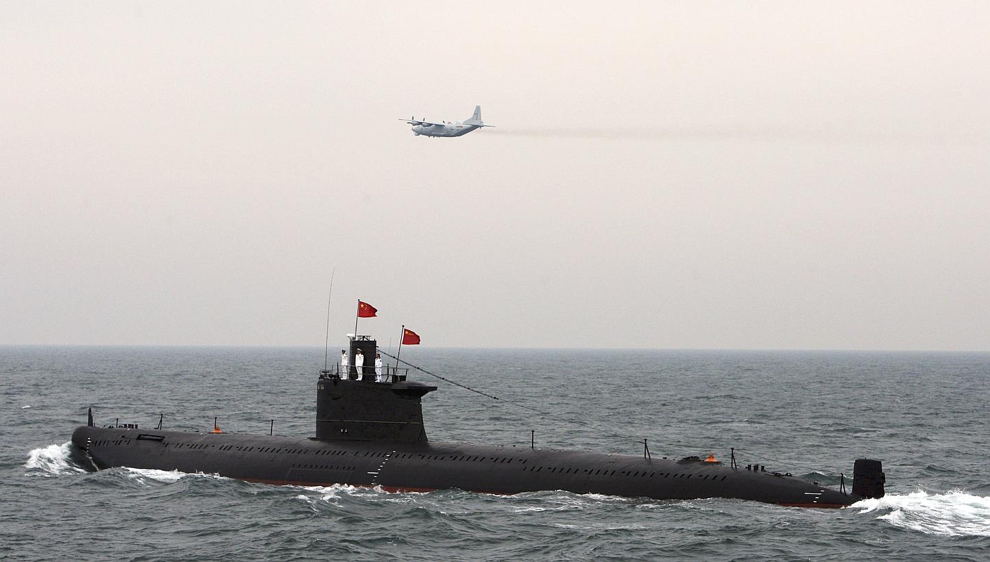A military aircraft flies past a Chinese Navy submarine at an international fleet review to celebrate the 60th anniversary of the founding of the People's Liberation Army Navy in Qingdao, Shandong province, in this April 23, 2009 file photo. -- PHOTO
